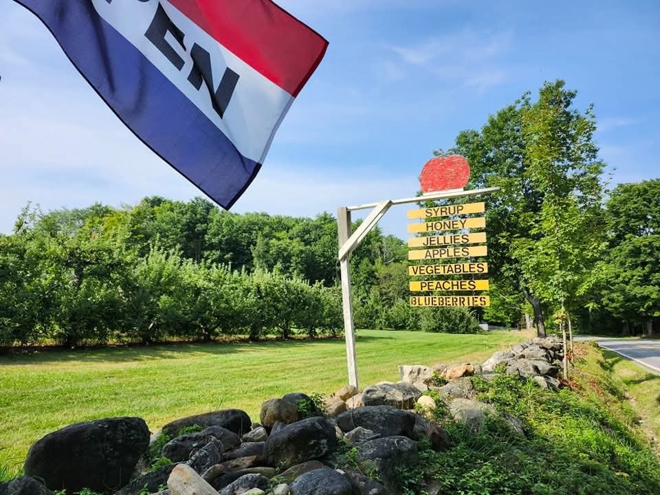 Meadow Ledge Farm’s roadside apple and produce sign beside a stone wall